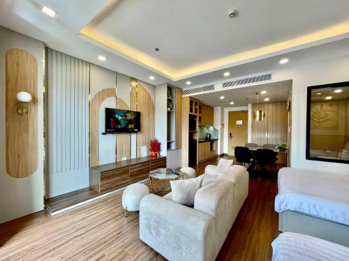 uma sala de estar com um sofá branco e uma sala de estar com uma cozinha em Wins House - FLC Sea Tower Quy Nhơn em Quy Nhon