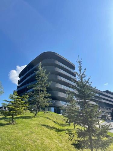 a building on a hill with trees in front of it at SAVOIE Apartments Bukovel in Bukovel