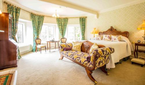 a bedroom with a bed and a couch and a table at Palé Hall in Bala