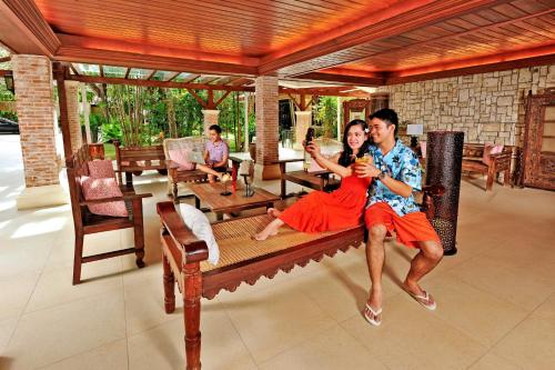 a man and a woman sitting on a bench at Costabella Tropical Beach Hotel in Mactan