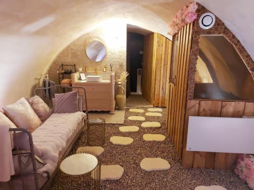 ein Wohnzimmer mit einem Sofa und einem Waschbecken in der Unterkunft L'Atelier Des Roses in Lunéville