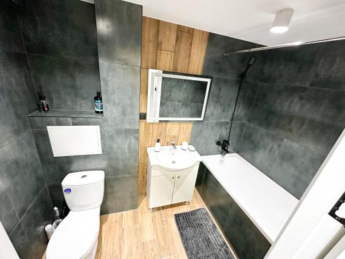 a bathroom with a toilet and a tub and a sink at Center Location 2 bedrooms in Chişinău