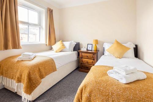 two beds sitting next to each other in a bedroom at Spacious 4-bedroom townhouse in the city center with free parking in Oxford