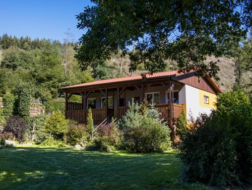 a small house with a porch on a lawn at Camping Karolina in Planá