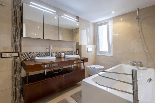 ein Badezimmer mit zwei Waschbecken und einer Badewanne und einer Toilette in der Unterkunft VILLA SIEMPRE DOMINGO MARBELLA in Marbella