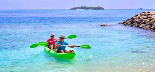 two people in a green kayak in the water at Beach Cottage in Rasdu