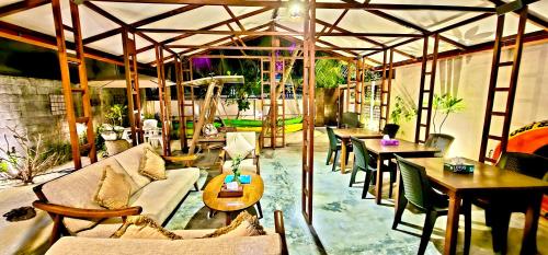 a room with tables and couches and tables and chairs at Beach Cottage in Rasdu