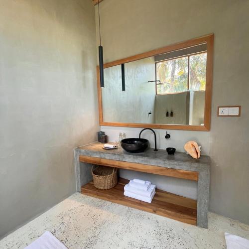 a bathroom with a sink and a mirror at La Playa Beach Club in Hiriketiya