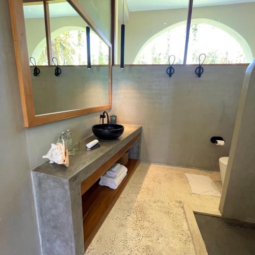 a bathroom with a sink and a mirror at La Playa Beach Club in Hiriketiya