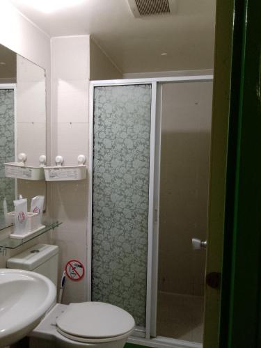 a bathroom with a shower and a toilet and a sink at 1bedroom with balcony in Manila