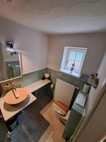 La salle de bains est pourvue d'un lavabo, d'une table et d'une fenêtre. dans l'établissement Ferienwohnung "Am Seebach", à Wangen im Allgäu