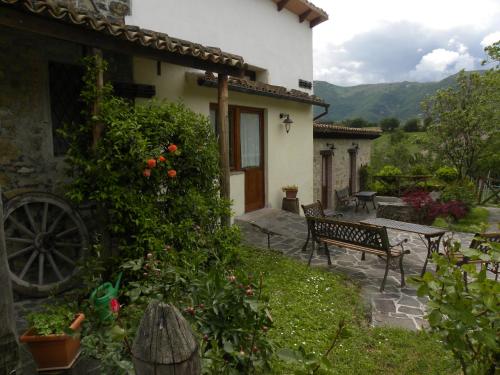 a garden with a bench and a house at B&B Caselunghe in Camerino