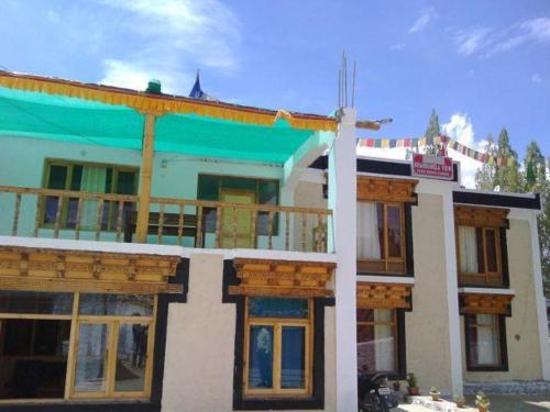 ein großes Gebäude mit blauem Dach und Fenstern in der Unterkunft Khardung Laa View Hotel in Leh