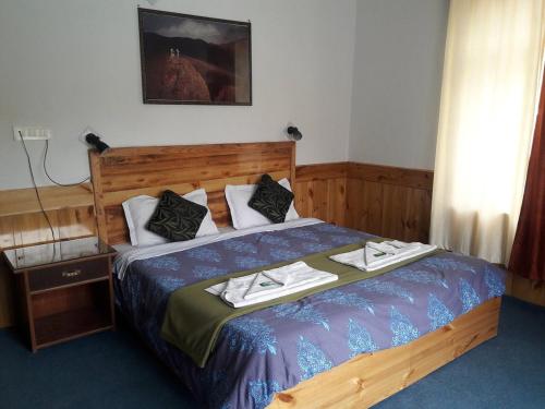 ein Schlafzimmer mit einem Bett mit zwei Handtüchern darauf in der Unterkunft Khardung Laa View Hotel in Leh