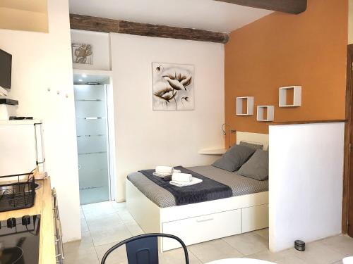 ein kleines Schlafzimmer mit einem Bett und einer Küche in der Unterkunft RAVISSANT STUDIO in Uzès