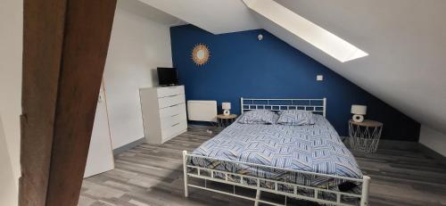 sypialnia z łóżkiem z niebieską ścianą w obiekcie Gîte Savigny en Sancerre w mieście Savigny-en-Sancerre