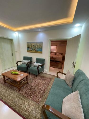 a living room with a couch and chairs and a table at Classy Hostel in Madaba