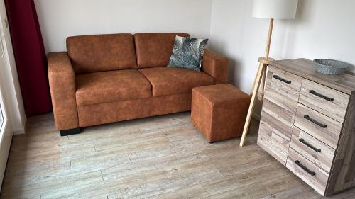 a living room with a brown couch and a table at Vakantiewoning de Schelp in Ellemeet