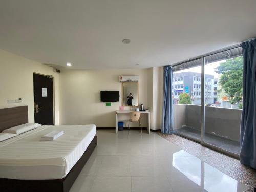 Cette chambre comprend un lit et une grande fenêtre. dans l'établissement HOTEL MALAYSIA, à Sibu