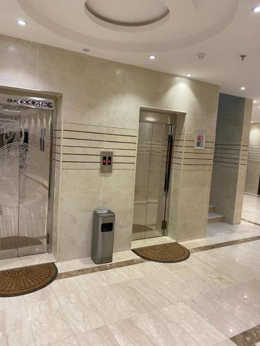 a bathroom with a shower and a trash can at شقق زمرد المروج للشقق المخدومة in Yanbu