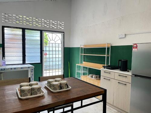 een keuken met een houten tafel en een koelkast bij Muslim Homestay Teluk Intan ( Hotel Style Room ) by Mr Homestay in Teluk Intan
