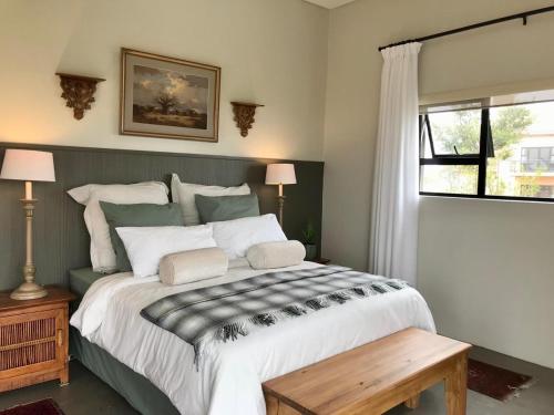 a bedroom with a large bed and a window at Highland Gate Belhaven in Dullstroom