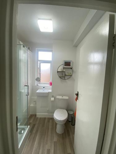 a white bathroom with a toilet and a sink at Stylish & Modern Central Studio Apartment Free parking in Southampton