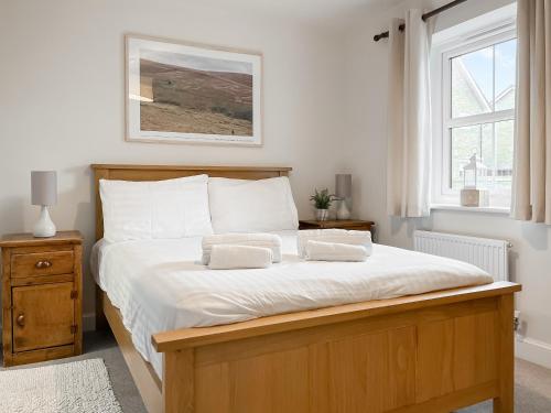 a bedroom with a large bed with two pillows on it at Oakstone House in Buxton