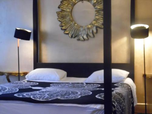 1 dormitorio con 1 cama con espejo en la pared en Demeure de 11 chambres avec piscine partagee et wifi a Pech Luna, en Pech-Luna