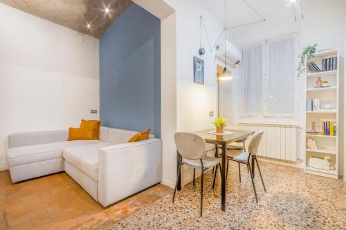 a living room with a white couch and a table at [A 2 passi da Piazza Grande] in Modena