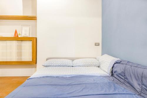 a bedroom with a bed with a blue comforter at [A 2 passi da Piazza Grande] in Modena