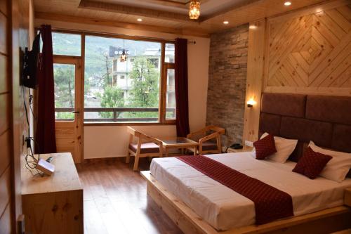 1 dormitorio con cama y ventana grande en The Riverview Serenity, en Manali