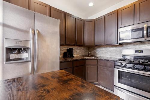 a kitchen with wooden cabinets and a stainless steel refrigerator at Comfortable Condo in the Heart of Bronzeville condo in Chicago