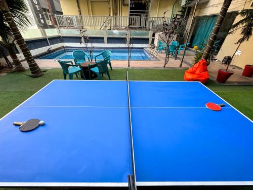 a blue ping pong table in front of a pool at The Wraveler Tapovan , Rooms & Dorms in Rishīkesh