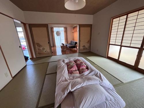 ein Schlafzimmer mit einem Bett in der Mitte eines Zimmers in der Unterkunft Kumamoto Castle House in Kumamoto