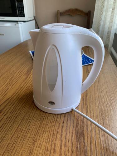 a white kettle sitting on top of a table at Jalaka, Nice 2-bedroom apartment - 1 big bed - 2 single bed in Tartu