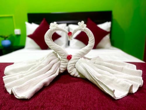 two towelsrendered to look like hearts sitting on a bed at Hema Holiday Villa in Trincomalee