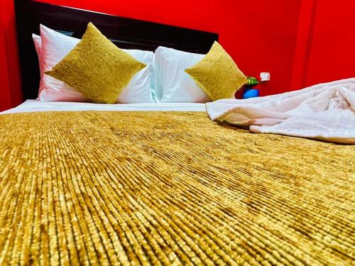a large bed with gold sheets and pillows at Hema Holiday Villa in Trincomalee