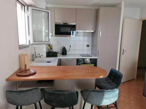 une cuisine avec une table en bois et quatre chaises dans l'établissement 