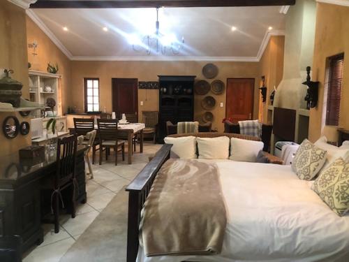 a bedroom with a large bed and a dining room at The Lemon Tree Self- Catering in Johannesburg