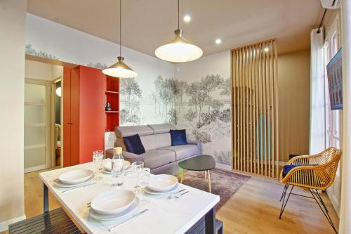 un salon avec une table et un canapé dans l'établissement 060 - Le Littre - Appartement 1 chambre, Central, Proche Maison carrée, Clim, 4personnes, à Nîmes