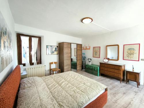a bedroom with a large bed and a dresser at La Maggiolina in Baveno
