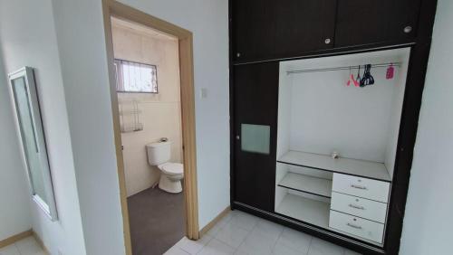 a bathroom with a black cabinet and a toilet at Eing's Homestay - Muslim And Mahram Only in Kajang