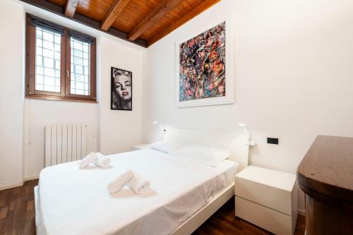 a white bedroom with two beds in a room at mirko apartment in Verona