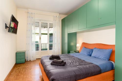 sypialnia z dużym łóżkiem z niebieskimi i zielonymi ścianami w obiekcie [Zona Stadio Olimpico] Ampio Bilocale con Balcone w Turynie