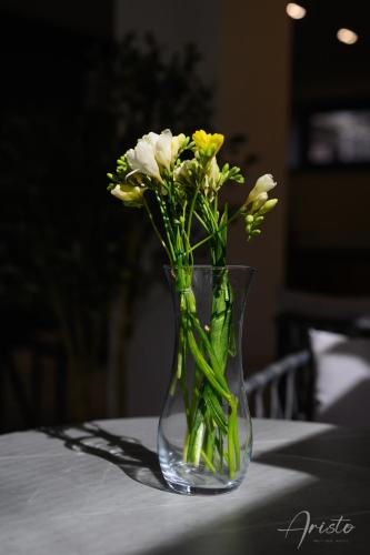 a glass vase with flowers in it on a table at Aristo Boutique Hotel in Artashat