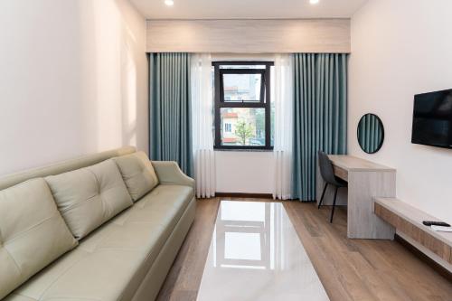 a living room with a couch and a desk at Capital Garden Hotel in Hanoi