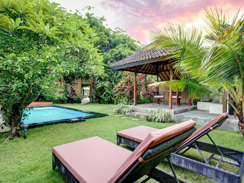 a backyard with a table and chairs and a pool at Villa Taman Rahasia in Seminyak