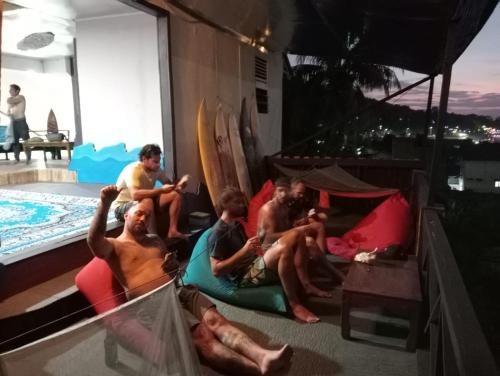 un gruppo di uomini seduti sul pavimento accanto alla piscina di SECOND HOPE LODGE a Padang