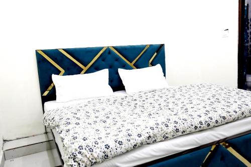 a bed with a blue headboard and two pillows at Jolly Hill Stay in Rāni Pokhri
